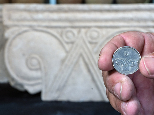 Modern Israeli five-shekel coin against the background of the capital.